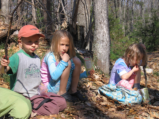 little kids eating snack in woods