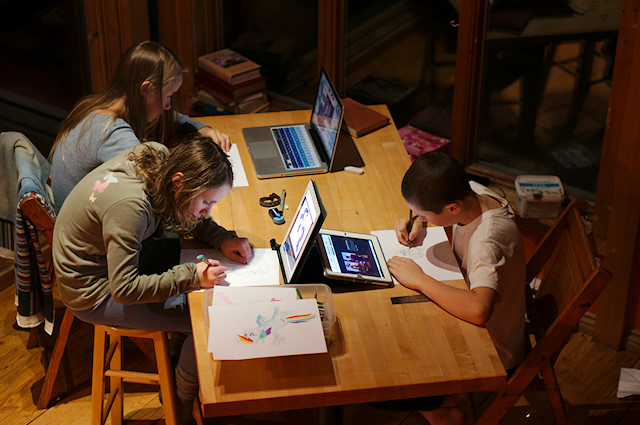kids drawing at table with tablets